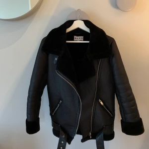 ***NA-KD jacka storlek 34*** - !!SÄNKT PRIS!! Säljer nu min supersnygga jacka från NA-KD. Den är i svart fake läder. Nästan som ny. Använd väldigt få antal gånger. Inga skador, fläckar etc. På hemsidan heter den ”Pilotjacka i bonded läder”. Ursprungspris 999kr. Bästsäljare. Kontakta mig om du är intresserad. Om många hör av sig, vinner det högsta budet.