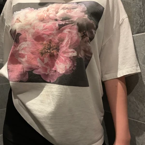 Overzised T-shirt med tryck - En vit oversized T-shirt med blommigt tryck 
