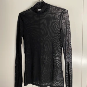 Mesh-topp - Svart, långärmad topp i mesh och med en liten turtleneck. Strl. M, men passar mig som är en S! Köpt på Gina Tricot 2017, använd max 5 ggr. Säljer för 100 kr exkl. frakt som tillkommer :) Riktigt snygg att ha under en t-shirt, med polokragen som sticker upp!