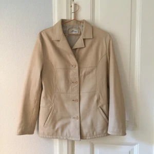 Skinnjacka i ljust läder  - Skinnjacka i läder. Oanvänd och i mycket bra skick. Passar en S/M beroende på hur en vill att jackan ska sitta 