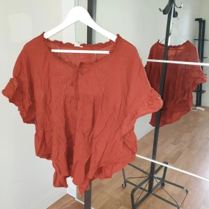 Topp  - Terrakotta färgad topp volang på ärm