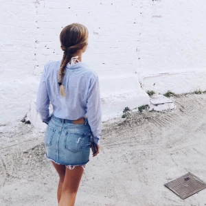  Jeanskjol med slitningar från Zara, storlek S - Kort jeanskjol med slitningar från Zara. Storlek S. Väl använd, men fortfarande fin i och med jeanstyg. Lite skrynklig lapp på baksidan. Utgå från färg på närbilder.