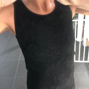 Svart kort Spetsklänning Ida Sjöstedt - Svart festklänning från Ida Sjöstedt i spets, kortare och figurnära. 