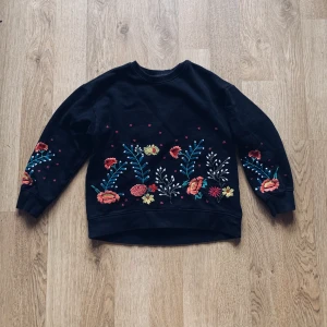 Svart Sweatshirt med blomtryck  - Säljer en svart Sweatshirt med blomtryck från Zaras barnavdelning i storlek 140 men passar ca. Nästan helt oanvänd. 100kr (+ frakt som köparen står för) 