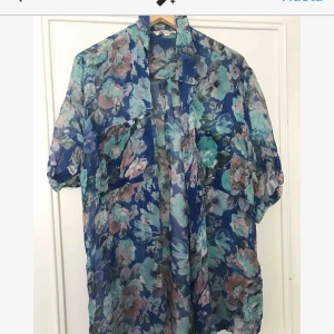  - Blus/kimono i blommigt skirt material. Perfekt i sommar. Strl S-L beroende på hur man vill att den ska sitta. 150 kr pp, 100 om vi möts upp.