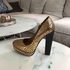  - Guld- och svartmönstrade klackar med platå i storlek 39. Endast använda en gång. Möts upp i Stockholm eller så står köparen för frakten 😁