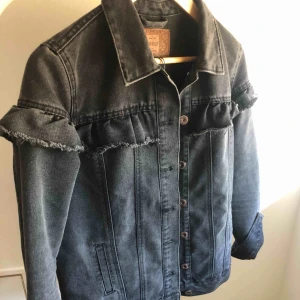  - Hej! Säljer en superfin jeansjacka i färgen svart/grå! Fin detalj men en volang. Det står stl 34 men jag som har XS/S/M passar den jätte bra och den är inte för liten! Ifrån Only