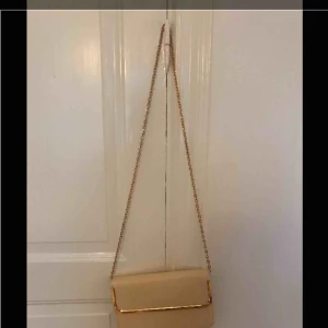  - Biege kuvertväska med guldig kedja från Forever 21. Lite missfärgad på baksidan. 