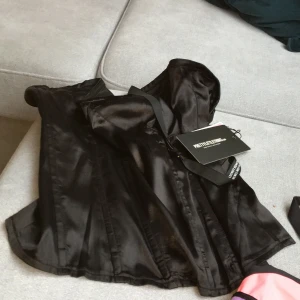 Corset ny, bikini ny! - Corset black satin st 14. Nytt! Bikini två delat: byxa m och bh s. Nytt! Produkter från Prettylittlething.com samt Hunkenmöller.