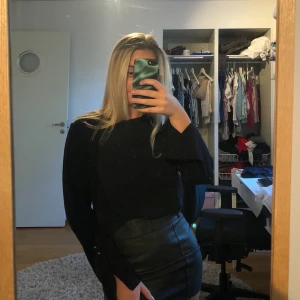 Svart blus - Svart blus som har ett glansigt material, skön och har hållt sig extremt bra, är alltså i ett gott skick, något utsvängda ärmar med guldiga knappar. 