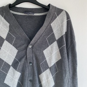 Trendig rutig kofta - Jättefin trendig kofta som går i gråa nyanser. Storlek M men en herr M. Köpt på secondhand och tvättad efter det men aldrig använd av mig, alltså i mycket gott skick. Frakt tillkommer