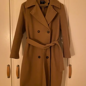 Beige kappa - Kappa från BooHoo, väldigt bra skick och endast använd fåtal gånger. Nypris 550kr mitt pris 200kr. Köparen står för fraktkostnaden som tillkommer.