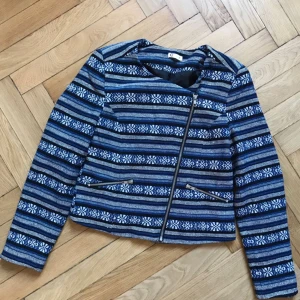  - Jacka i blått mönster i litet kortare modell, liknande ylle, fodrat med sidenmaterial. Superfin och nästan oanvänd! Storlek 38, men passar även mig som är 34/36.