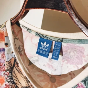  - ADIDAS ORGINALS. Confete BF Trefoil Shirt. Multicolor pattern. Unisexmodell t-shirt i storlek 38  