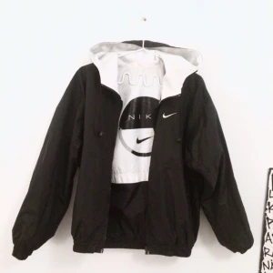  - världens bästa nike-vindjacka som varit ett av mina favvoplagg länge. köpt second hand. det bästa är att den är reversible, alltså går att vända ut och in för olika looks (den ena sidan är helsvart, den andra svart och vit med nike-logga på ryggen, se bilder). passar en XS–M beroende på hur man vill att den ska sitta.     🔥 obs! den vita delen (främst under luvan) är något missfärgad, lite åt det gula hållet. dock inget man tänker på när den är på :-) nike-märket är något slitet, se bild. 