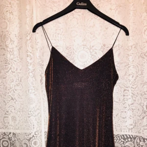  - Glittrig långklänning från gamla HM (Hennes) i trendig 90-tals vibe!⭐️ Stretchigt tyg, spaghettistraps och slits på båda sidor (ca 50 cm). Går till ankeln på mig som är 170. Normal i storlek och ger en urläcker siluett!😍 köpare står för frakt. Fråga gärna om fler bilder, mått mm!