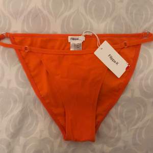 En orange bikiniunderdel från Filippa K. Säljs pga att den inte såg så bra ut på mig/storleken men är helt ny med skyddet kvar på. Jag möts gärna upp annars kan frakt diskuteras vid köp! :) 