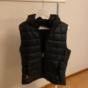 MANGO väst - Svart väst med luva från mango i storlek L. Luvan är avtagbar. 