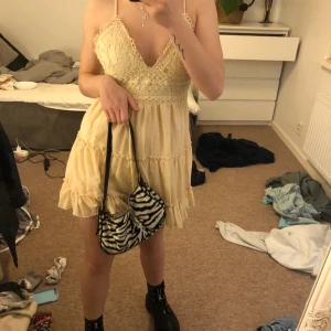 Klänning med öppen rygg - Snygg beige klänning från occult med snörning i ryggen. Superfin med brodyr på bröstet. Använd fåtal gånger. Skitsnygg till boots och skinnjacka tex:)