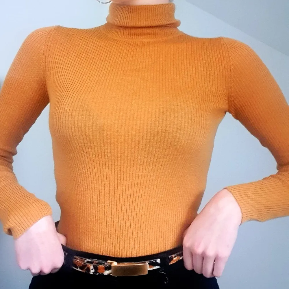 Den här orangea ribbade tröjan är perfekt till både blåa jeans och svarta byxor. Tröjan är stretchig och mjuk vilket gör den väldigt bekväm och inte alls stram som liknande tröjor kan vara.. Toppar.