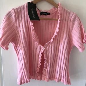 Stickad topp med knapp - En superfin och trendig stickad tröja från prettylittlething! Den är helt ny och har lappen kvar, i storlek M! Hör av er med frågor🌸🌸