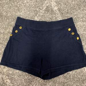 Sköna marinblåa shorts med guldknappar vid sidan. 