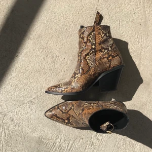 Faux Snakeskin Boot - Boots i ormskinnsimitation strl 38! Sparsamt använda pga inte riktigt min stil men så snygga! Kan fraktas. Nypris 890:- vill jag minnas. 