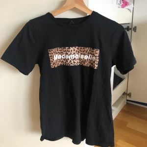 Leo print tröja  - Leo print t-shirt med text ”madmoiselle” från Gina Tricot. Superfin & bra basplagg i garderoben. Säljer pga använder aldrig den. St S