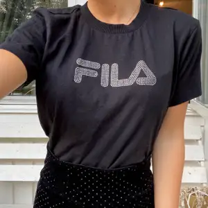 Perfekt t-shirt med lite glam från Fila! Väldigt sparsamt använd så skicket är toppen. Jag är XS så t-shirten sitter normalt på mig, men tror egentligen det ska vara en crop top🖤 Fraktar eller möter upp i Karlstad💕