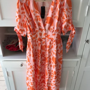 Klänning - Prislapp kvar. Klänning med djupare urringning. 