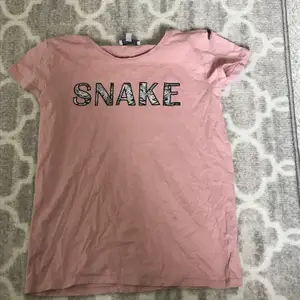 En rosa t-shirt från Ullared där det står snyggt på med ormskinns monster i texten den är i storlek 170 men passar även  XS och S💕