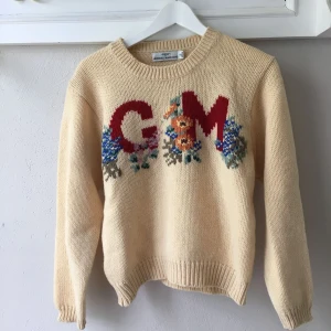  - Ljusgul stickad tröja från Guess. Liten maska som gått upp på ärmen (se bild). 100% ull 