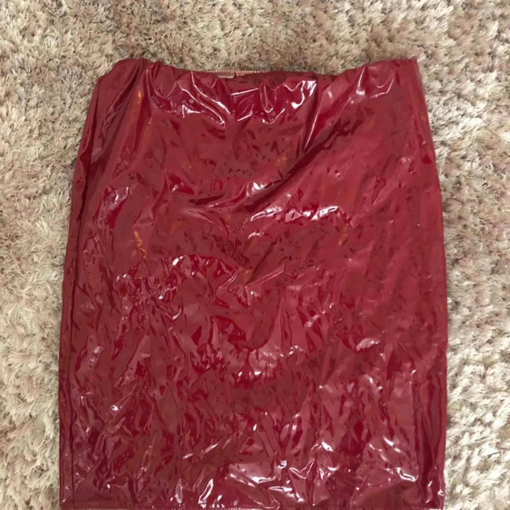 Trendig röd lackjol från Bohoo. Aldrig använd (lite skrynklig på bilden pga legat ihopvikt i min garderob). Är väldigt strechig i materialet så passar både stl 36 & 38.. Kjolar.