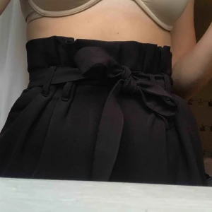  - Svarta vida Paper bag byxor med skärp i midjan från Bikbok i storlek S. Använda 2 ggr:)