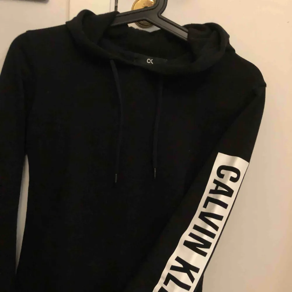 En svart hoodie från Calvin Klein med texten på ena armen Storlek XS Köpt från boozt är från Calvin Klein performance. Använd max 3 ggr. Hoodies.