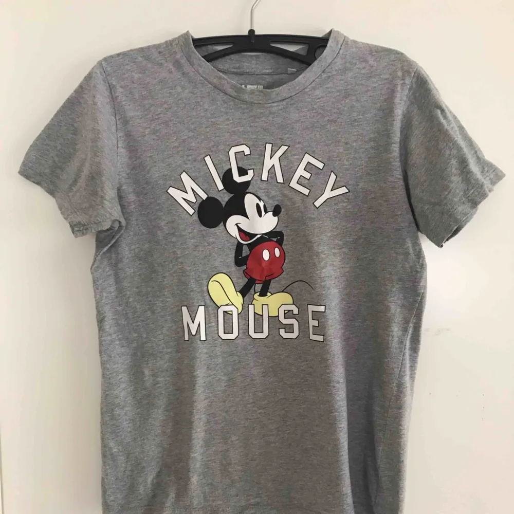 En grå T-shirt med Mickey Mouse på, T-shirten är sparsamt använd, utan fläckar eller andra tecken på användning. Säljer den för att den tyvärr inte används lika mycket som den borde. . T-shirts.