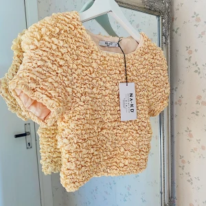 Topp från NAKD strl 34 - Säljer en helt oanvänd topp från nakd i strl 34. Nypris 550 kr. Lappen kvar. Ganska stretchig så skulle kunna passa 36 också. Säljer då den inte kommit till användning. 