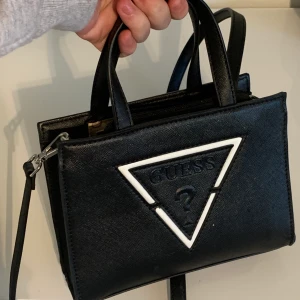Guess Väska - Guess Väska köpt i USA. Givetvis Äkta!! Banden kan tas av. 450kr och jag bjuder på frakten <3 Skriv gärna vid intresse!