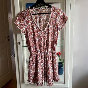 Byxdress  - Blommig byxdress med spetsvollanger, köpt på hollister för ca 2 år sedan men knappt använd. Praktpris tillkommer.