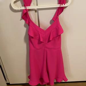 En fin klänning/shorts jumpsuit med jätte fin chock rosa färg, sitter jätte fint med massor av detaljer fram och bak. 