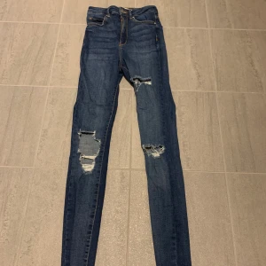 Jeans storlek 34 - Slitna högmidjade jeans från gina tricot i fint skick. Storlek 34