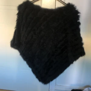 Pälsponcho  - Svart pälsponcho med äkta päls. Köpt i Danmark. One size. Frakt tillkommer på 79kr