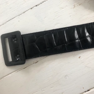 Midje skärp - As cool svart glansigt midje skärp. Köpt på en vintage butik men aldirg använd. Köparen står för frakt 50kr
