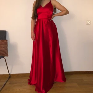 Röd bal sidenklänning  - Använts 1 gång. Storlek S men fungerar på M också. Jag är 168 cm lång och den når ner till golvet med klackar på. Den har fickor som inte syns alls och ett slits vid benet som är diskret. Jag kan posta klänningen men då står köparen för frakt😊