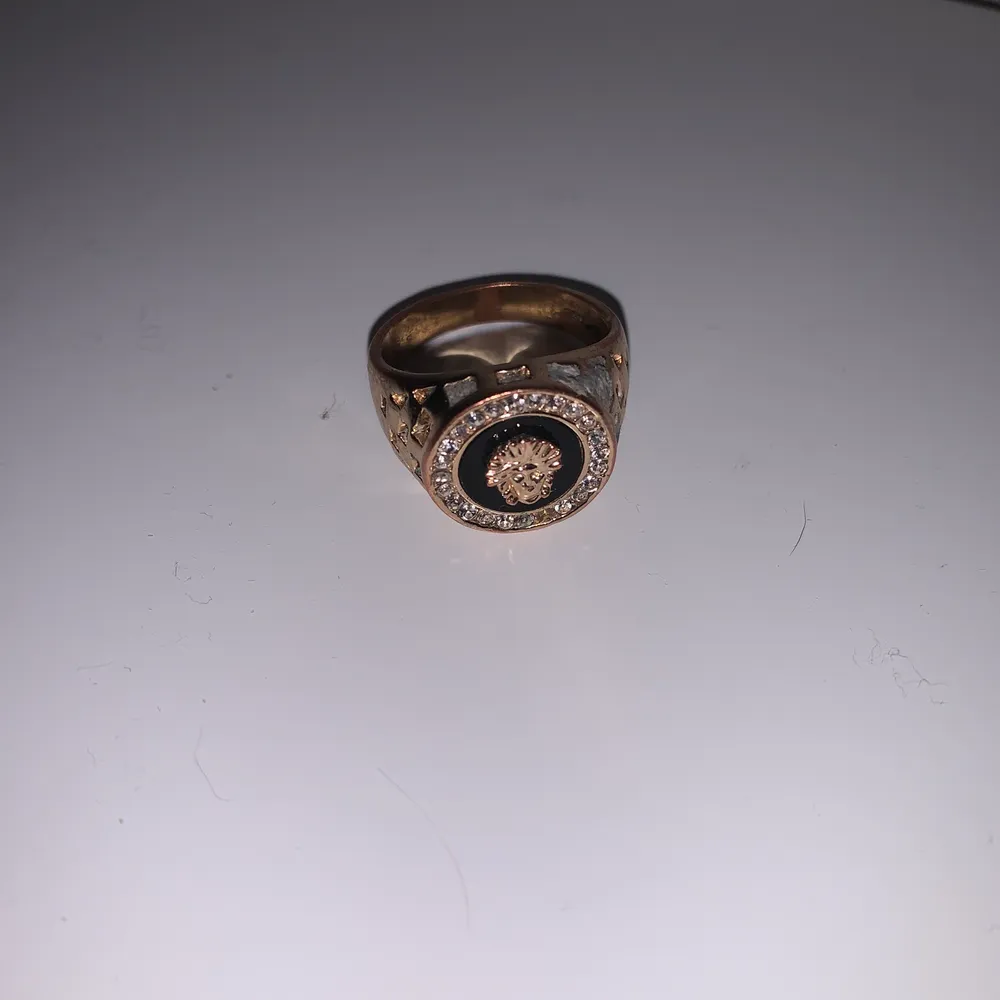 Säljer denna Versace ring som jag inte använder längre. Inte äkta och säljer den för 70 kr. En liten diamant är borta men inget som syns på långt håll.. Accessoarer.