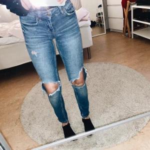 Blåa jeans - Blåa jeans med hål på knäna. Från Gina Tricot men de säljs inte längre. Dragkedjor på båda sidorna av benen. Jeansen har en liten slitning insida lår kan skivka bild om ni skulle vara intresserade💖