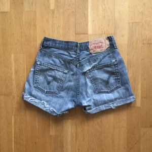  - Levis-shorts i modell 501 i storlek W30. Men ganska små i storleken så passar säkert bra på w29 också. Med snygga slitningar lite varstans samt bak vid ena fickan. Säljer dessa då de tyvärr är för små för mig.