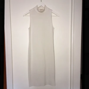  - Vit ribbad figursydd klänning i stretchigt material, den slutar precis över knäskålarna på mig som är 1,64! :)