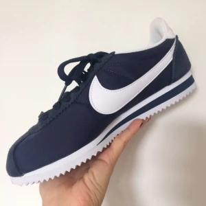  - Nike Cortez! Ett par skitsnygga klassiska Nike-sneakers i färgen Navy. Storlek 38 men passar säkert en person med storlek 37. Jag har själv 38/38,5 men dessa var lite för små och därför säljer jag dem :( Aldrig använda, endast legat i förpackning. Betalning via Swish/mötas i centrala Stockholm ❤️
