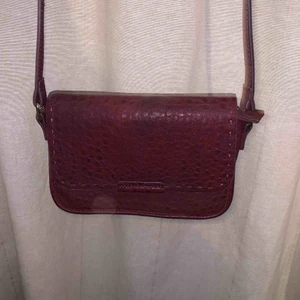  - Vinröd väska från Åhlens. Gulddetaljer.     Betalas med swish. Kan mötas upp i Halmstad eller skicka mot frakt som betalas av köparen. 